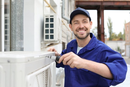 Technician working on outdoor HVAC unit