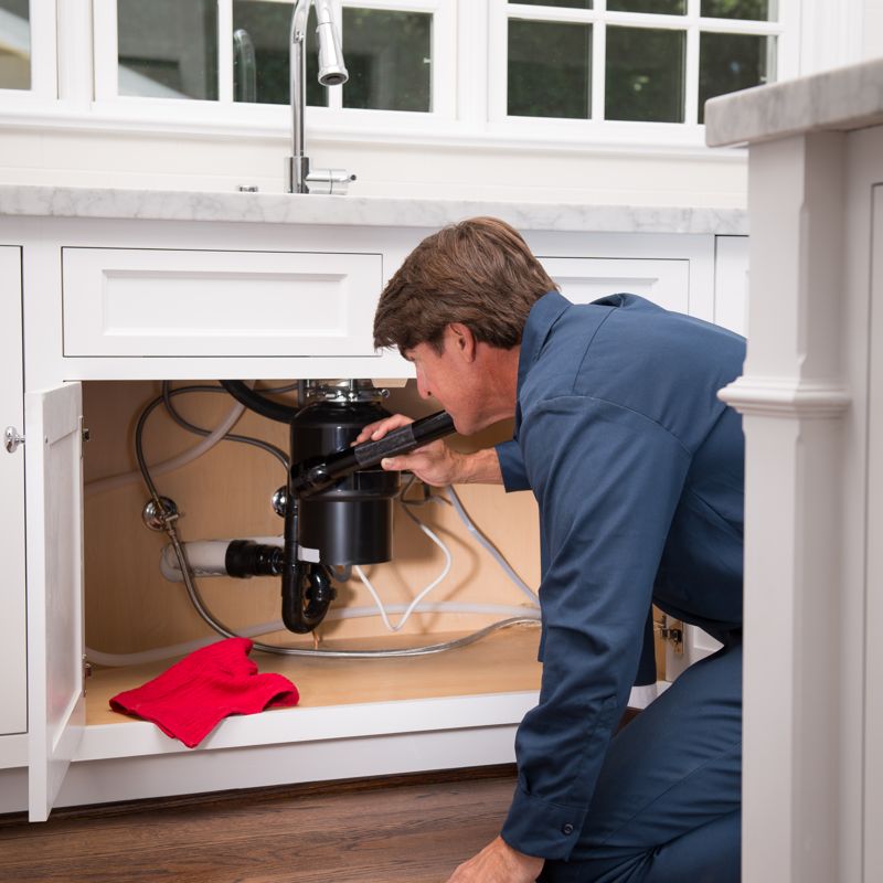 technician inspecting garbage disposal